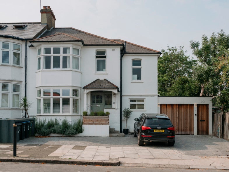 The view from the street shows discreet side entrance leading to the hidden home