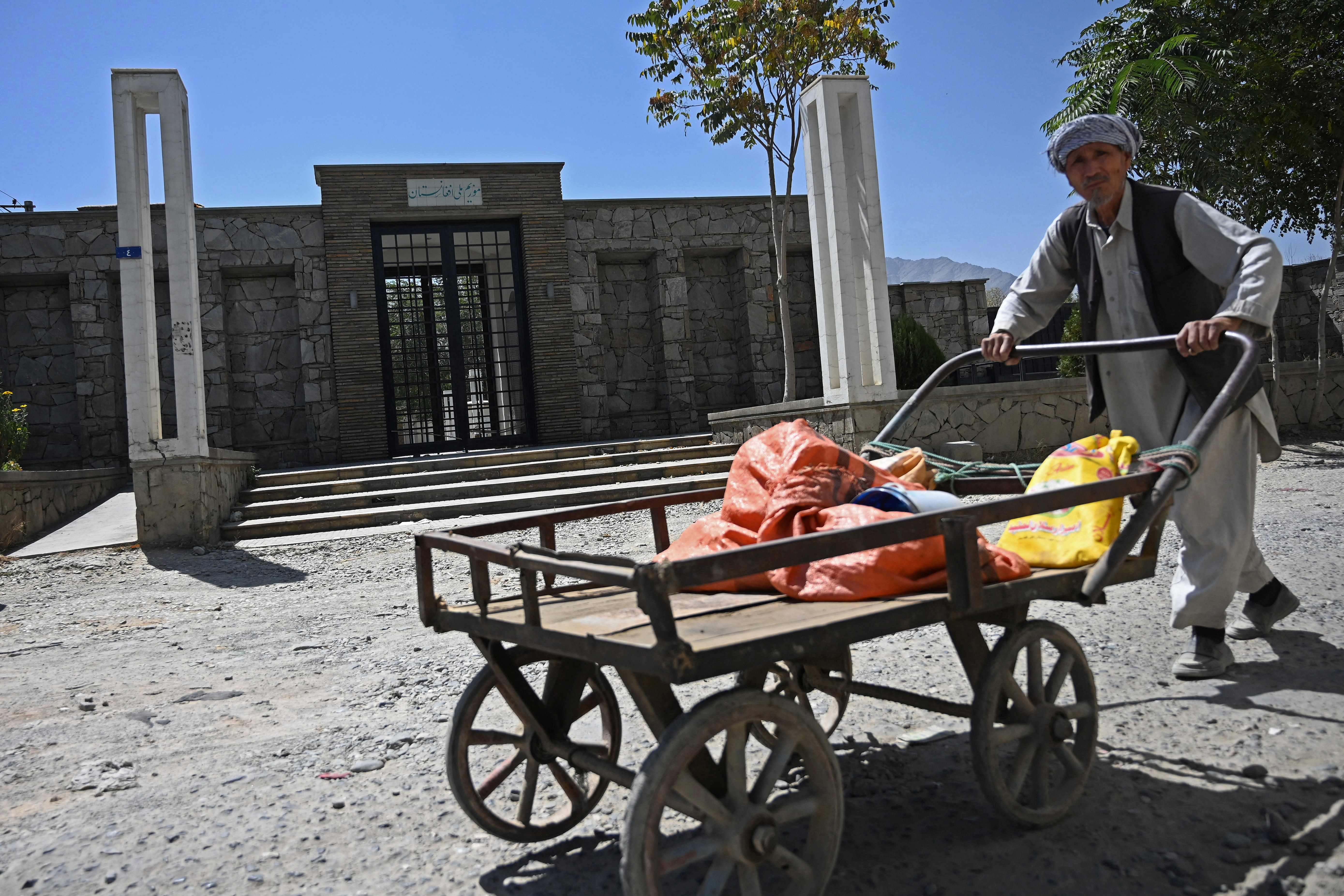 A man pushes his handcart past the main entrance of the closed National Museum in Kabul on Wednesday