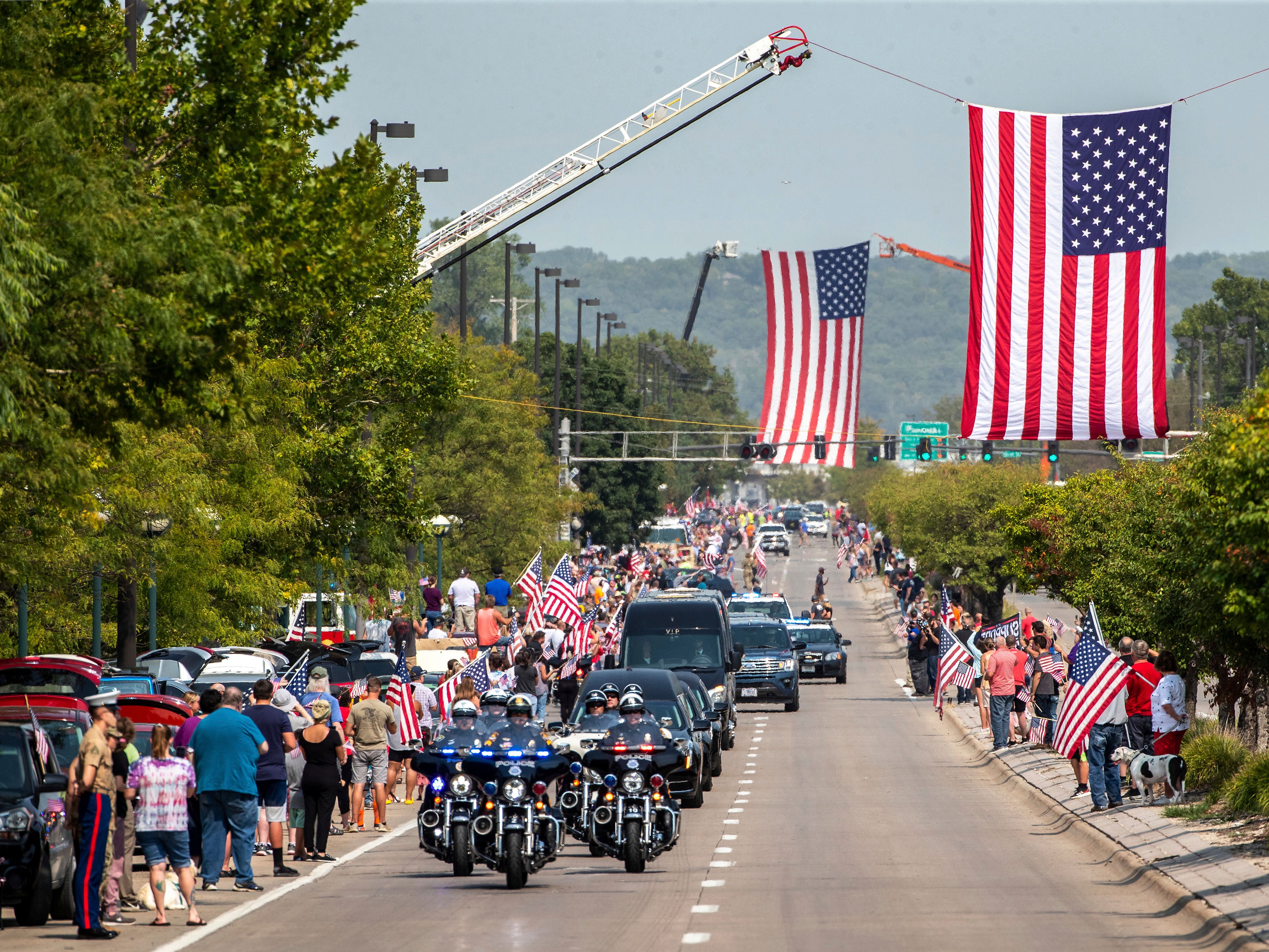 <p>People line Abbot Drive to pay their respects to Marine Cpl. Daegan Page as the procession carrying his body drives through Omaha, Neb. on Friday Sept. 10, 2021</p>