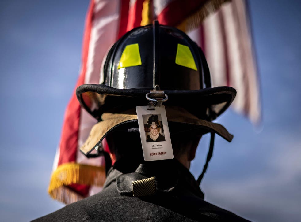pA firefighter wearing the photo badge of a victim on his helmet, pauses for a moment of silence as he participates with first responders, victim's family members and supporters in the 2021 Colorado 9/11 Memorial Stair Climb at the Red Rocks Park and Amphitheatre on September 11, 2021 in Morrison, outside Denver, Colorado. - Participants walk nine laps around the Red Rocks Amphitheater, which is equivalent to the 110 floors of the World Trade Center. (Photo by Chet Strange / AFP) (Photo by CHET STRANGE/AFP via Getty Images)/p