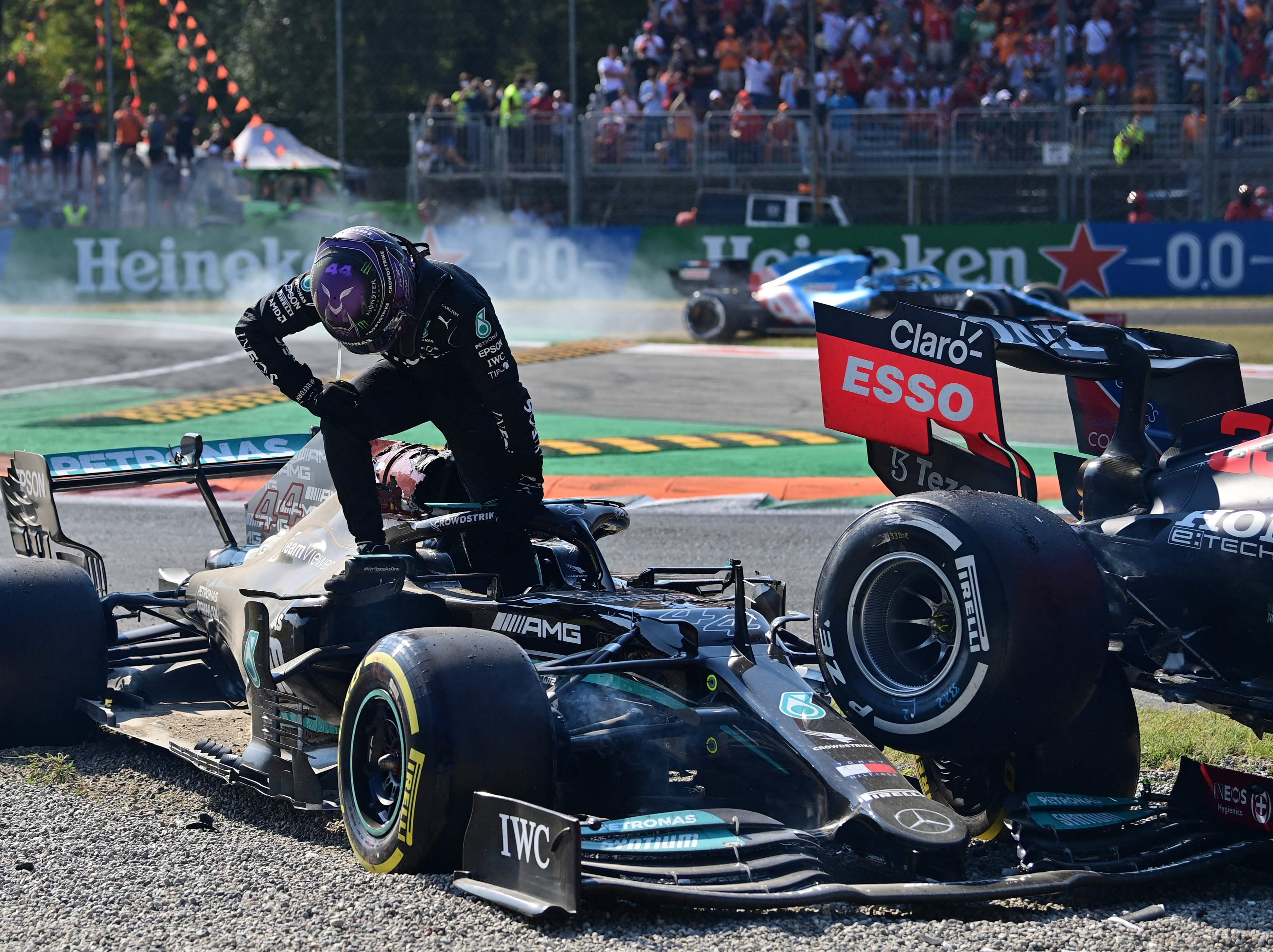 Lewis Hamilton climbs out of his car after a crash with Max Verstappen