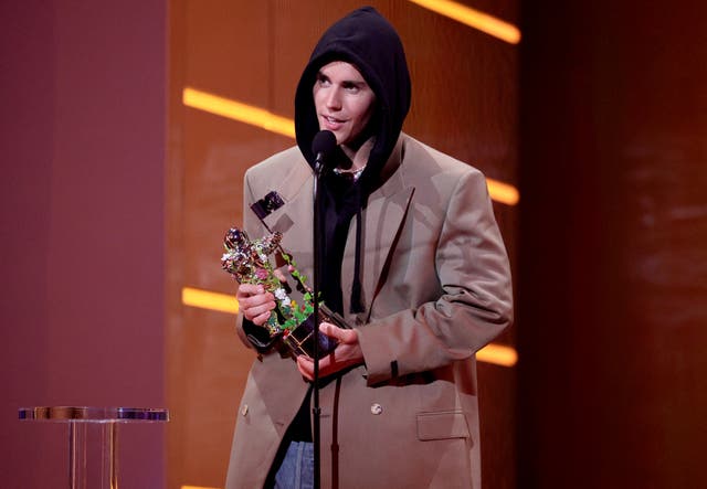 <p>Justin Bieber accepts the Artist of the Year award onstage during the 2021 MTV Video Music Awards</p>