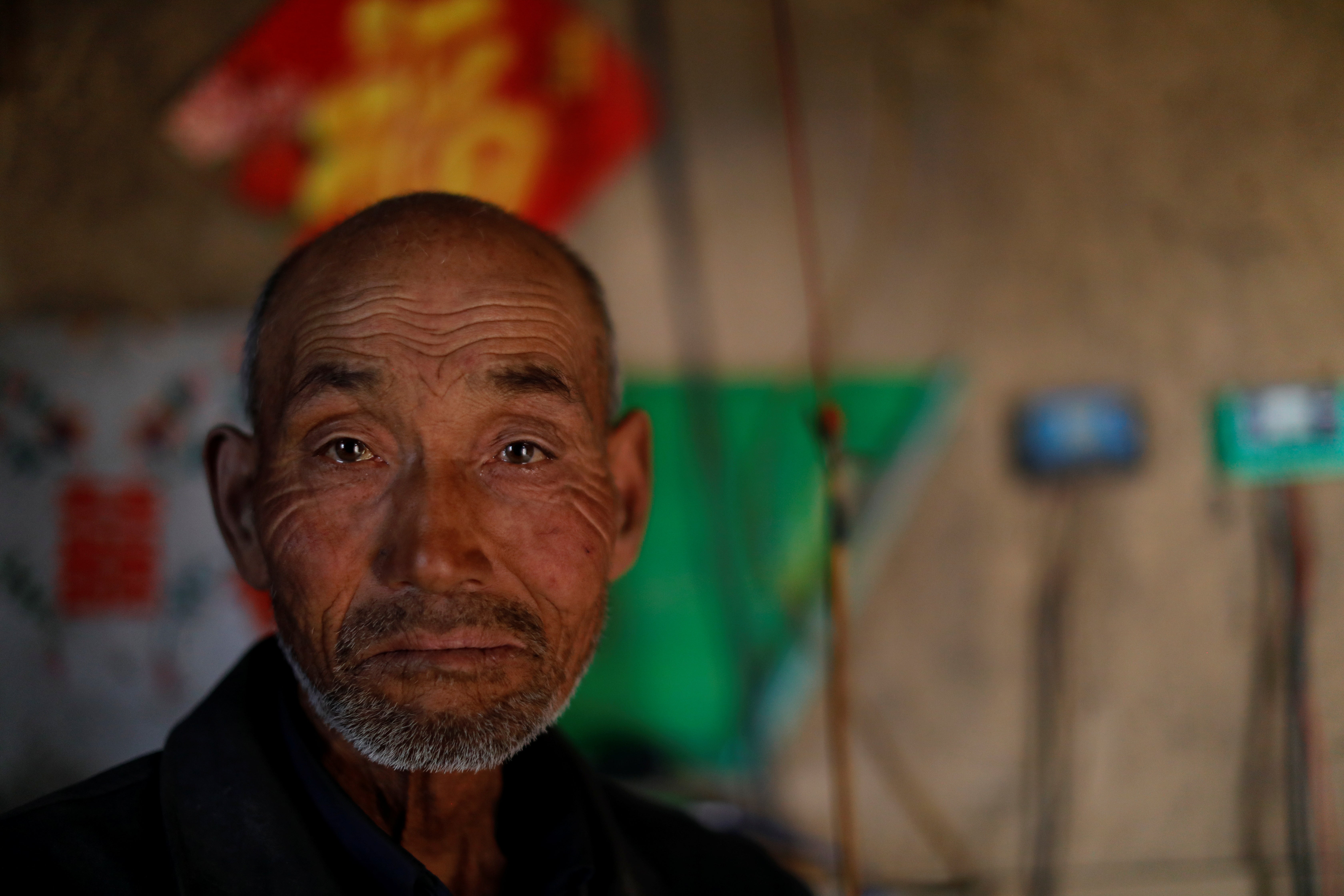 Li Youfu poses for a picture at his house