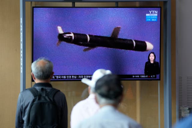 <p>Seoul residents watch a  news programme featuring a North Korean photo captioned, ‘North Korea’s long-range cruise missiles tests’ </p>