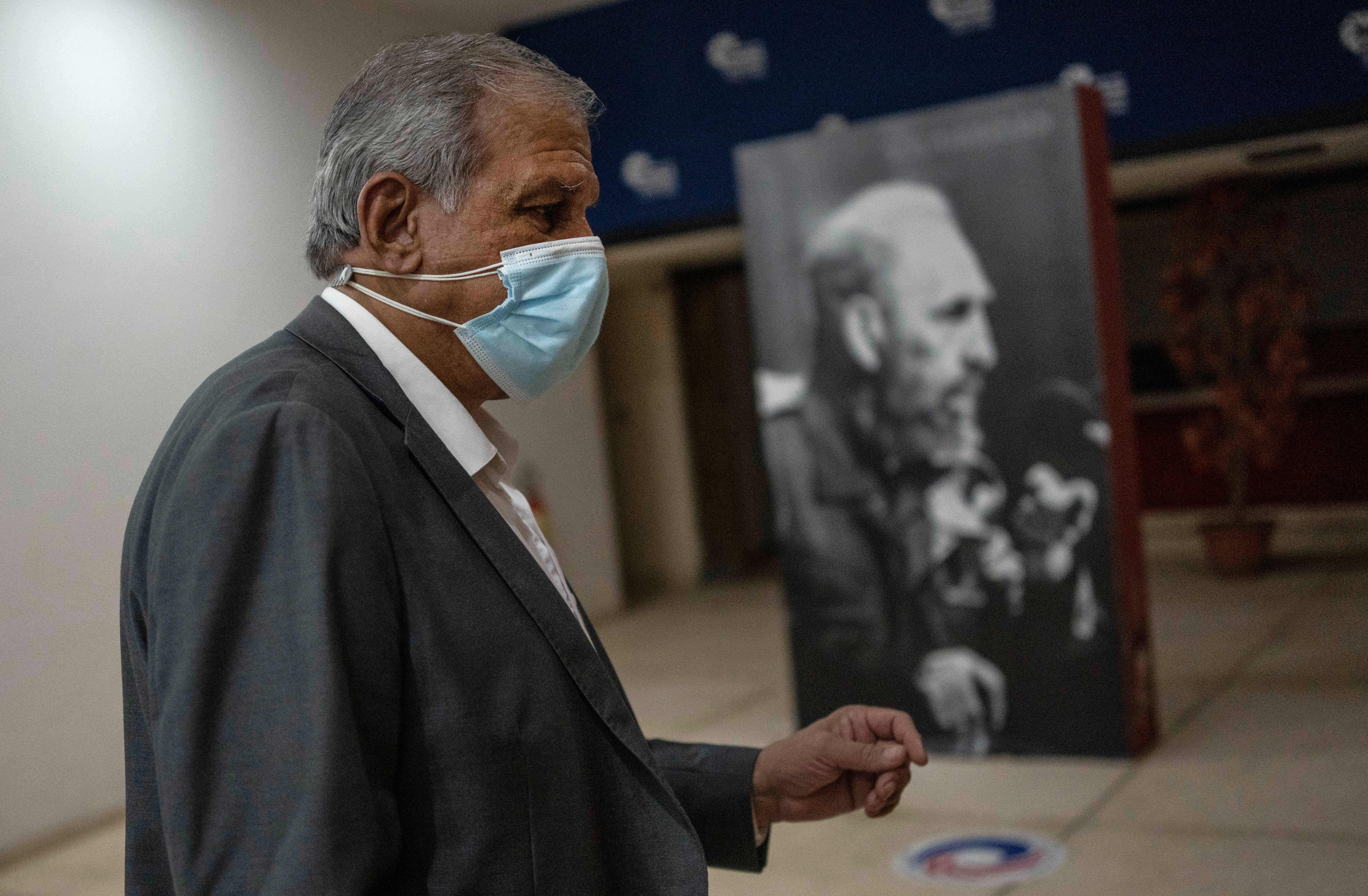 Mitchell Joseph Valdes Sosa, the director of the Cuban Neurosciences Center, walks past a photo of Fidel Castro before a press conference about symptoms of Havana Syndrome