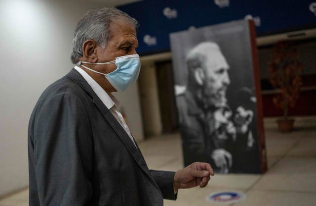 <p>Mitchell Joseph Valdes Sosa, the director of the Cuban Neurosciences Center, walks past a photo of Fidel Castro before a press conference about symptoms of Havana Syndrome </p>