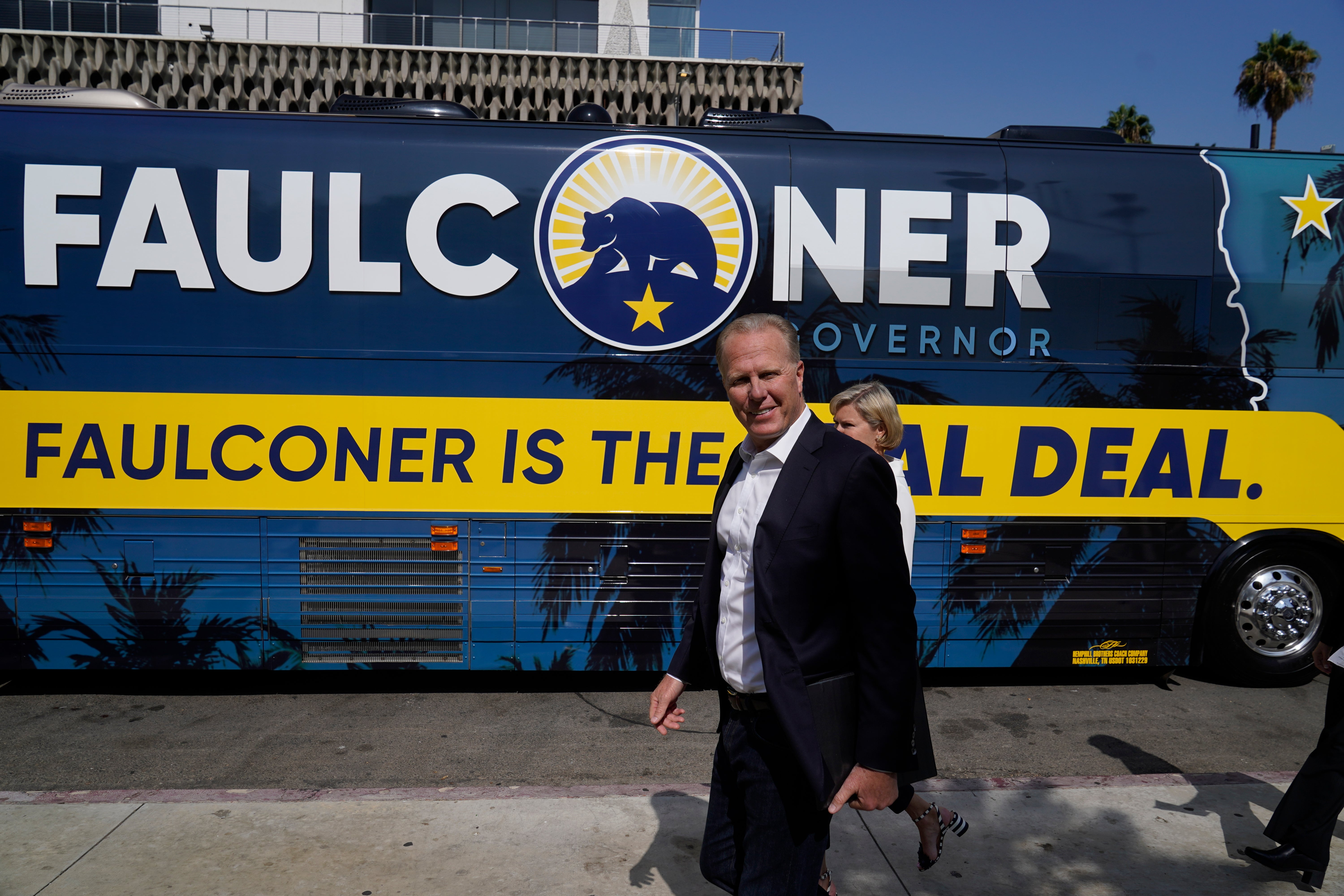 California gubernatorial candidate and former San Diego mayor Kevin Faulconer and his wife, Katherine Faulconer, arrive on a charter bus at a campaign stop to promote his "women's empowerment plan" at MacArthur Park in Los Angeles Monday, Aug. 30, 2021. The Republican is among 46 candidates seeking to replace Democratic Gov. Gavin Newsom in the Sept. 14 recall election. (AP Photo/Damian Dovarganes)