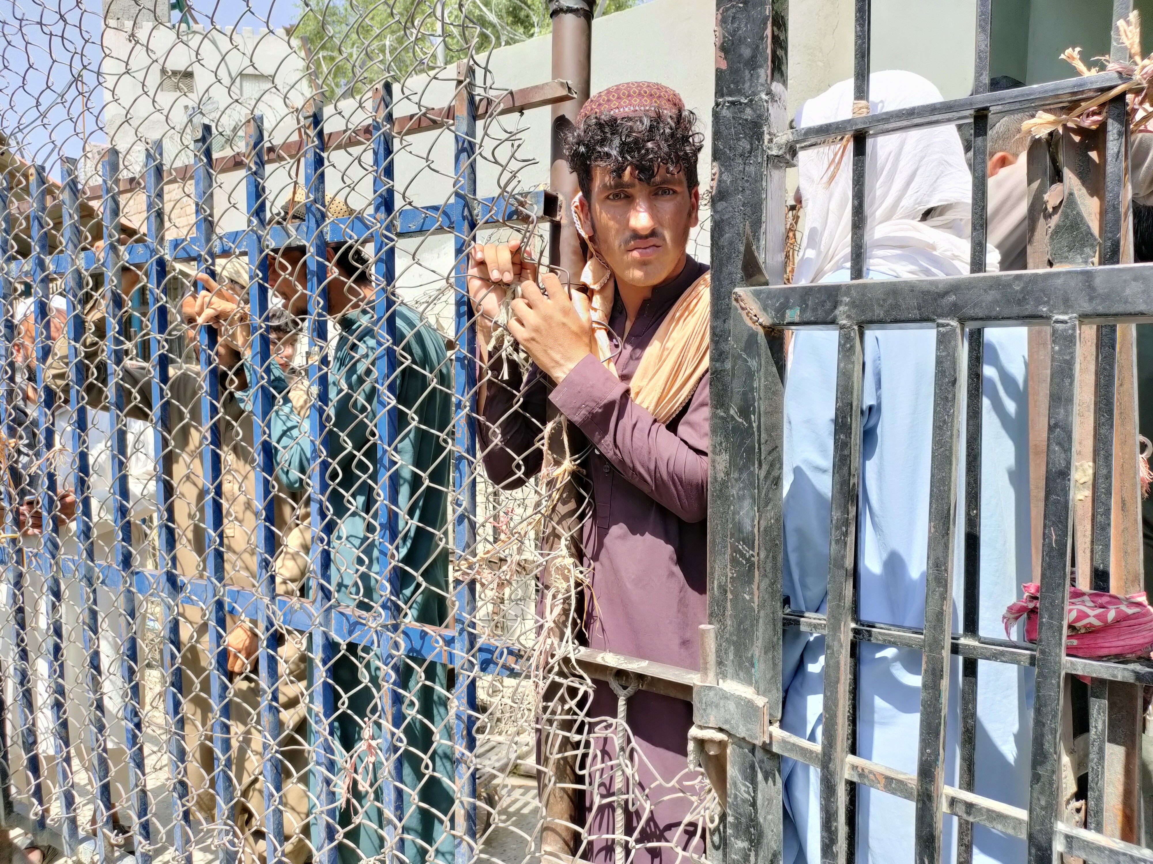 Afghan people wait at the Torkham border crossing to enter Pakistan