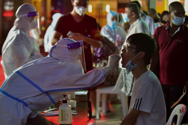 <p>File: A health worker collects swab sample from a resident during a mass Covid-19 test in Putian in southeast China's Fujian province on 12 September 2021</p>