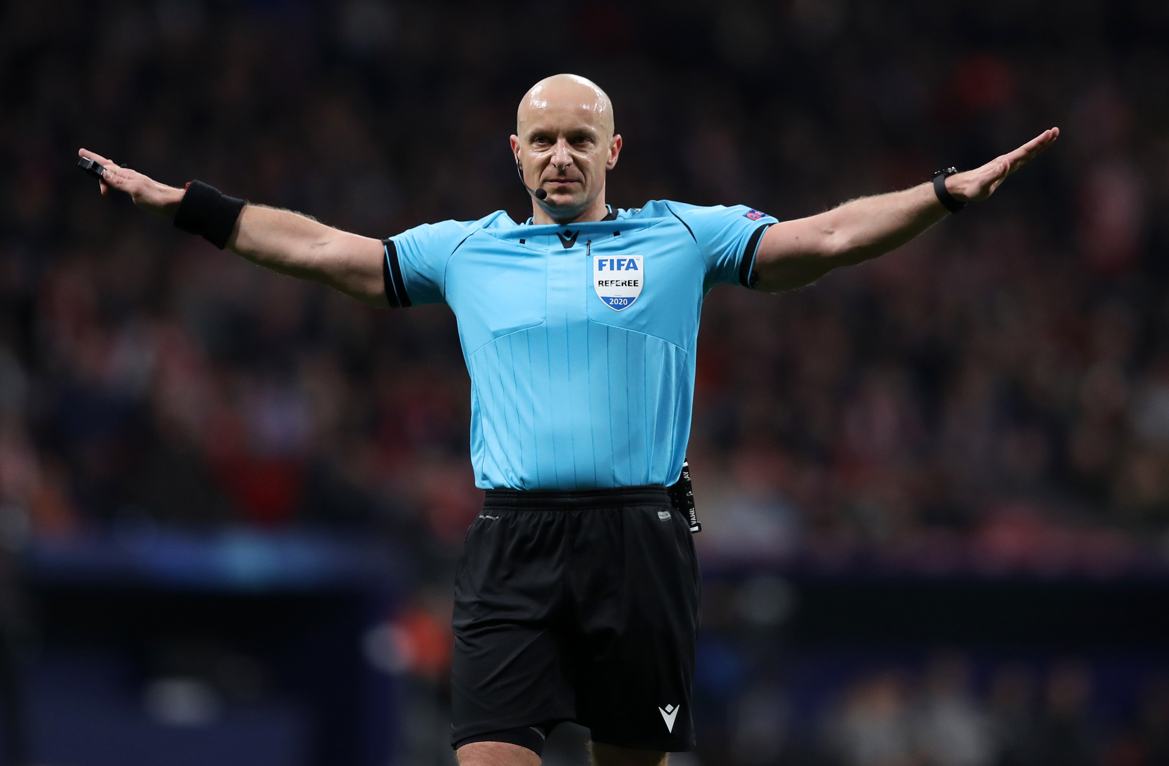  Szymon Marciniak, a bald male referee, is apologizing to Bayern Munich players after making a controversial call during a match.