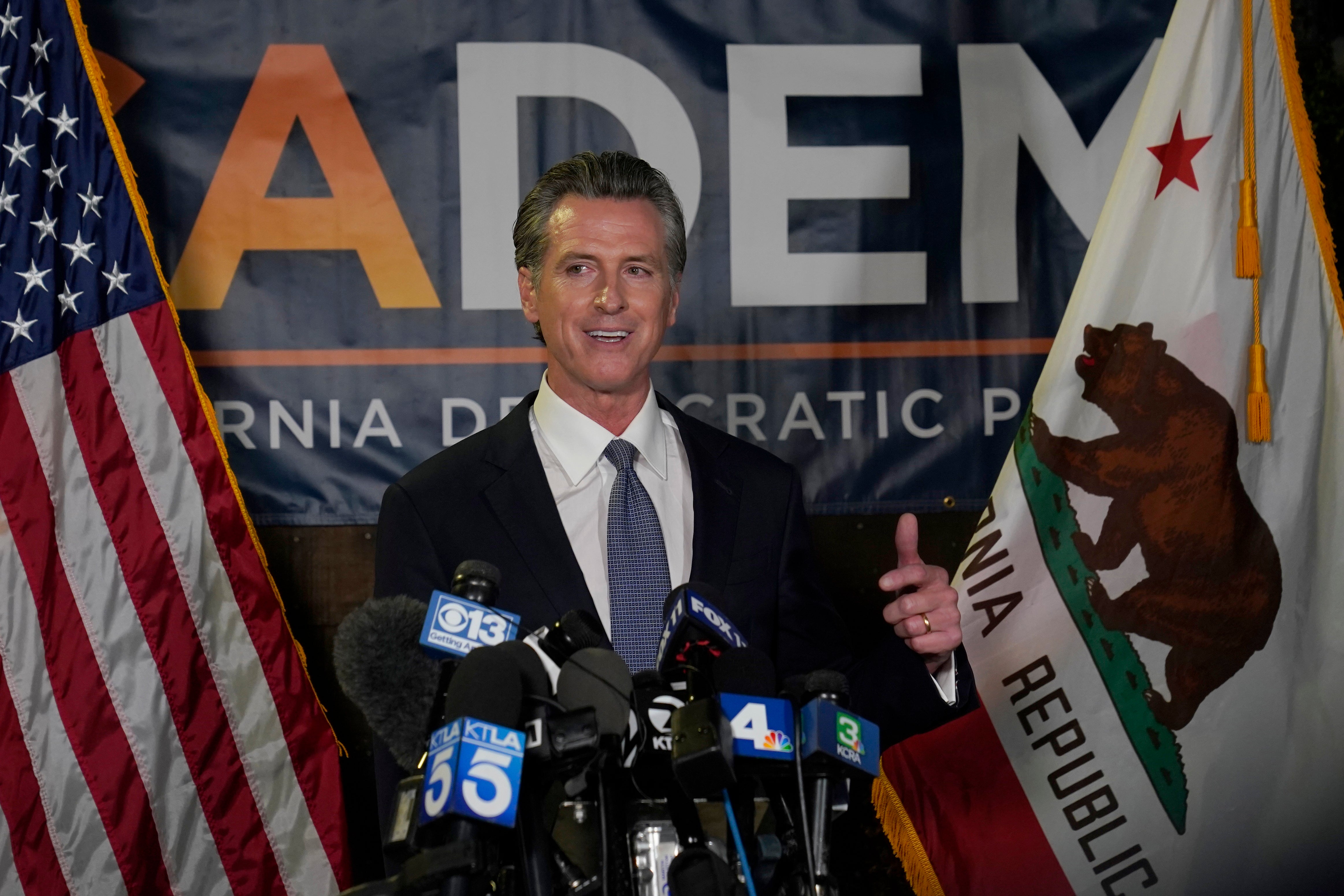A victorious Newsom talks to reporters at the state’s Democrat HQ in Sacramento on Tuesday