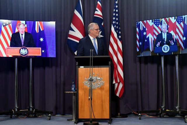 <p>Australia's prime minister Scott Morrison appears on stage with video links to Britain's prime minister Boris Johnson  and US president Joe Biden</p>
