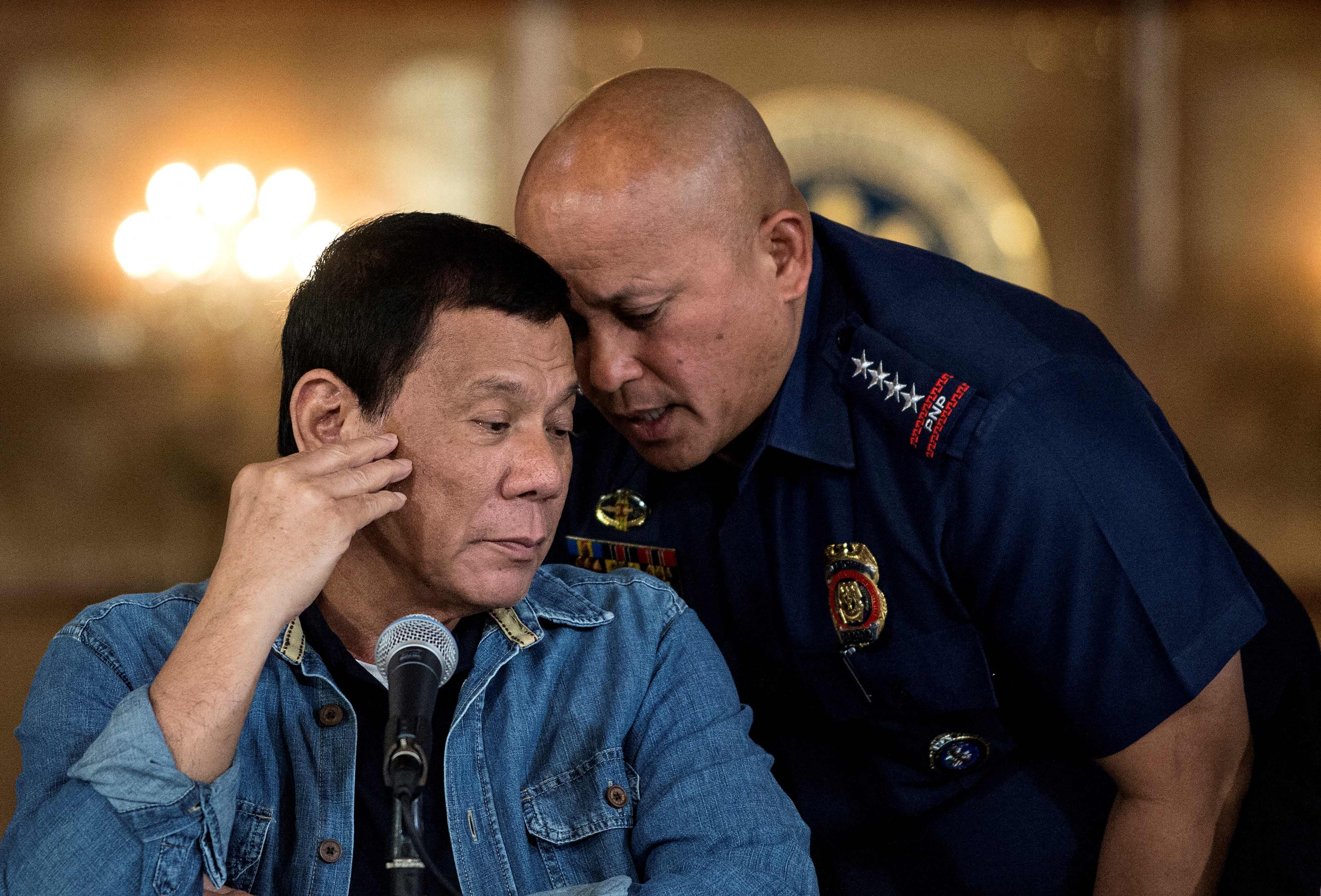 File Rodrigo Duterte (L) talking to then Philippine National Police (PNP) director general Ronald Dela Rosa (R) during a press conference at the Malacanang palace in Manila.