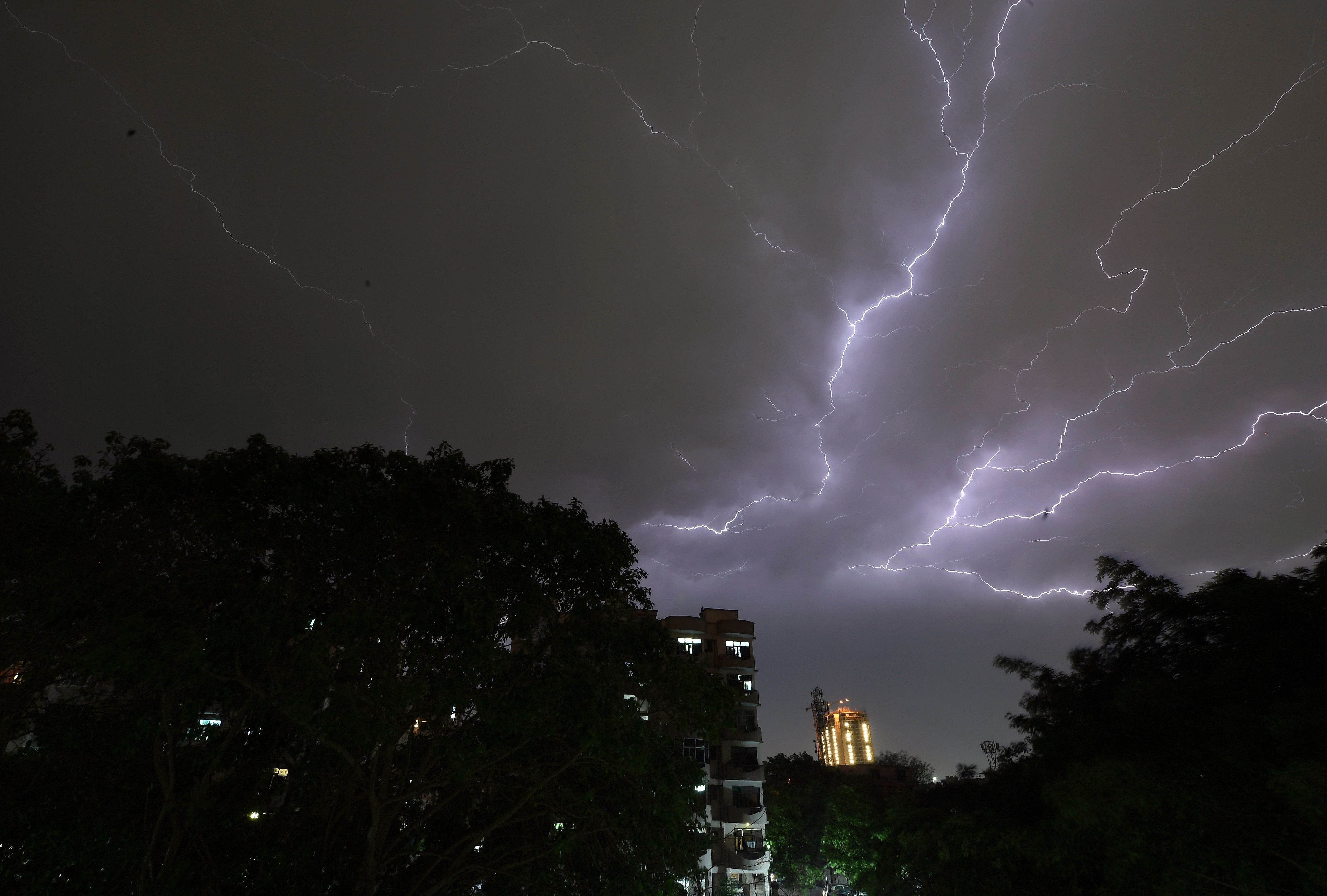Lightning strikes over residential apartments during a thunderstorm on the outskirts of New Delhi