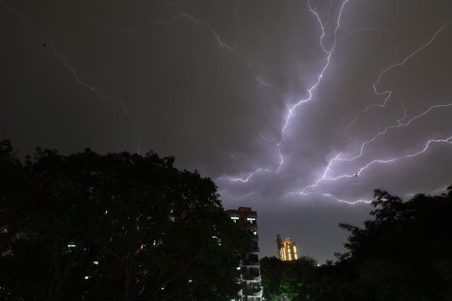 <p>Lightning strikes over residential apartments during a thunderstorm on the outskirts of New Delhi</p>