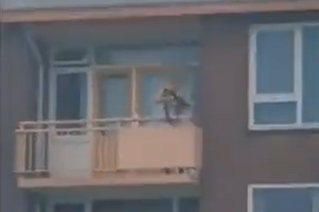 <p>In videos shared online, a shirtless man can be seen aiming a crossbow from a second floor balcony</p>