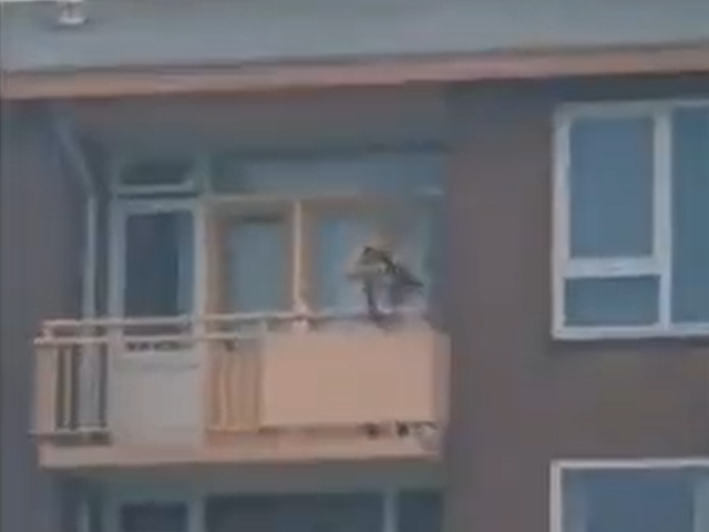 <p>In videos shared online, a shirtless man can be seen aiming a crossbow from a second floor balcony</p>