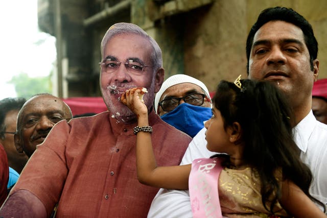 <p>A girl offers cake to a life-size cutout of Indian Prime Minister Narendra Modi 17 September in Ahmedabad, Gujarat </p>