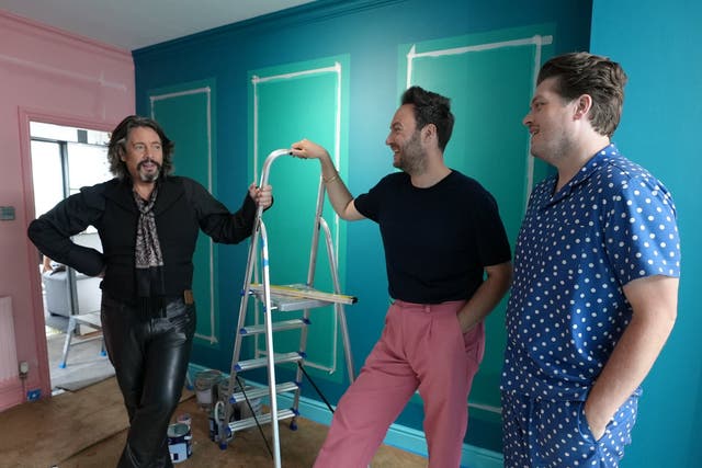 <p>Part dandy highwayman, part sex dungeon captive: Laurence Llewelyn-Bowen amuses Jordan Cluroe and Russell Whitehead in the rebooted ‘Changing Rooms'</p>