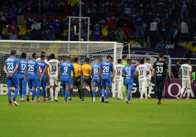 <p>Jugadores del Cruz Azul y Monterrey abandonan la cancha luego de que el árbitro suspendiera el juego por 10 minutos debido a cánticos homofóbicos durante un partido de fútbol de vuelta de semifinales de la Liga de Campeones de la CONCACAF en el estadio Azteca de la Ciudad de México, el jueves 16 de septiembre de 2021.</p>