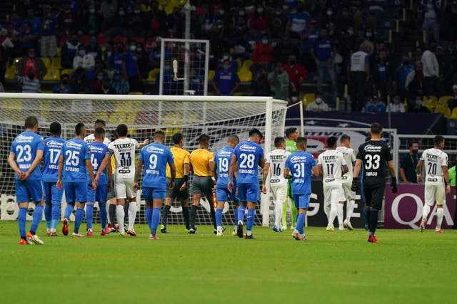 <p>Jugadores del Cruz Azul y Monterrey abandonan la cancha luego de que el árbitro suspendiera el juego por 10 minutos debido a cánticos homofóbicos durante un partido de fútbol de vuelta de semifinales de la Liga de Campeones de la CONCACAF en el estadio Azteca de la Ciudad de México, el jueves 16 de septiembre de 2021.</p>