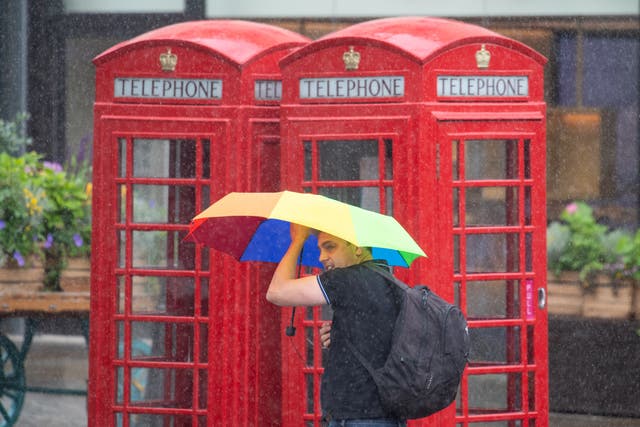 <p>Areas of England will see torrential rain this weekend (Pictured: A man shelters from downpours in Covent Garden, Central London) </p>