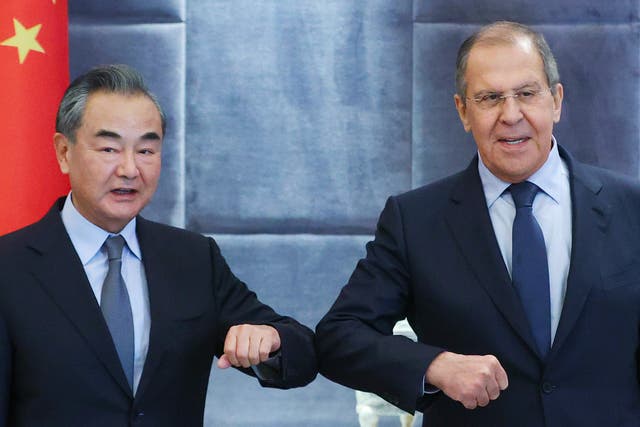 <p>China's Foreign Minister Wang Yi (L) and his Russian counterpart Sergei Lavrov bump elbows as they meet for talks</p>