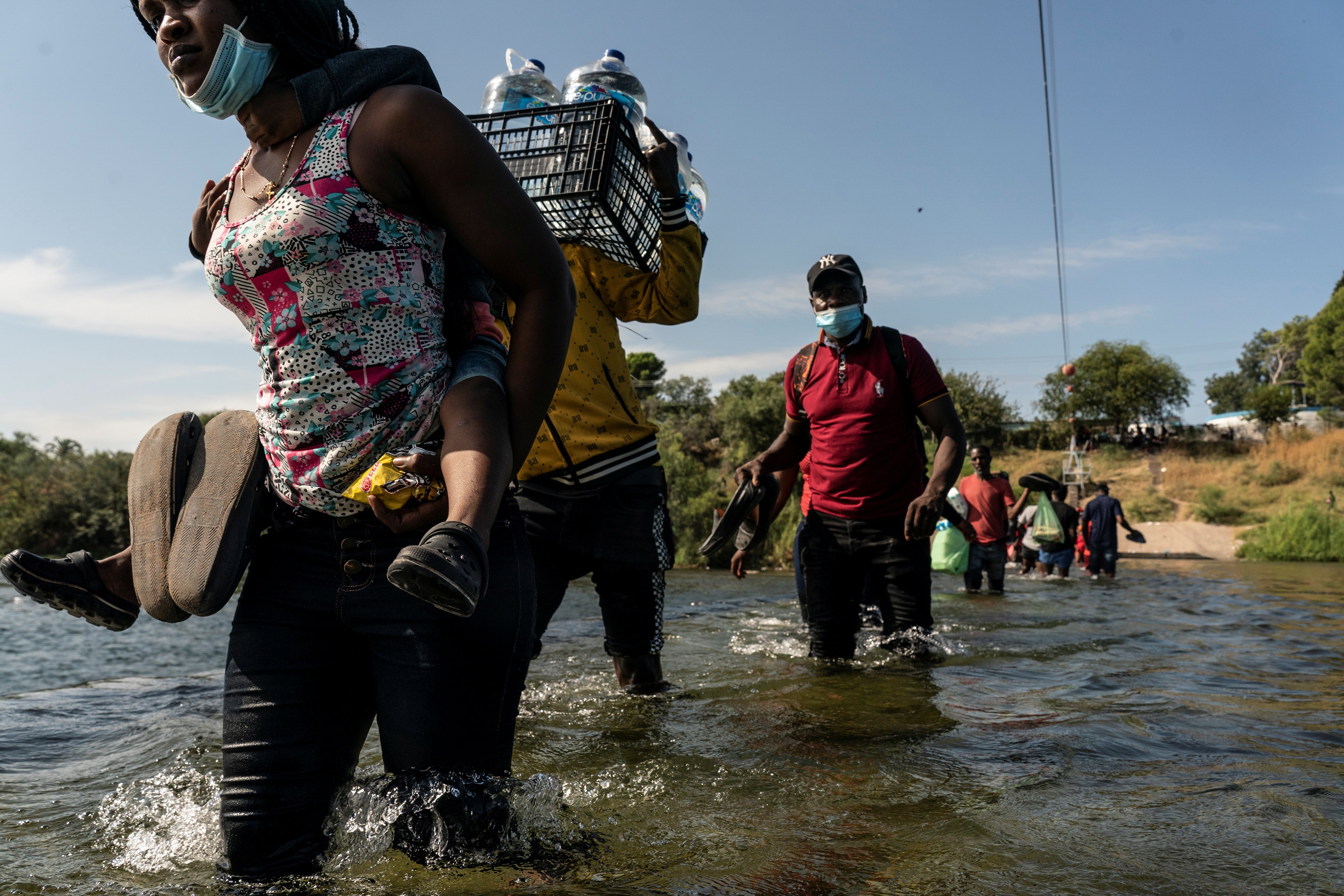 Asylum-seeking migrants reach the Rio Grande river, not far from The International Bridge.