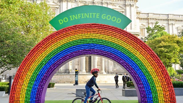 Hugo, 7, from London rides past a 4x7 metre rainbow arch, made entirely of recycled aluminium cans, which has been installed by recycling initiative 'Every Can Counts', in partnership with The City of London Corporation in front of St Paul's Cathedral in London, to encourage members of the public to recycle their drinks cans ahead of recycling week, which starts on 20 September
