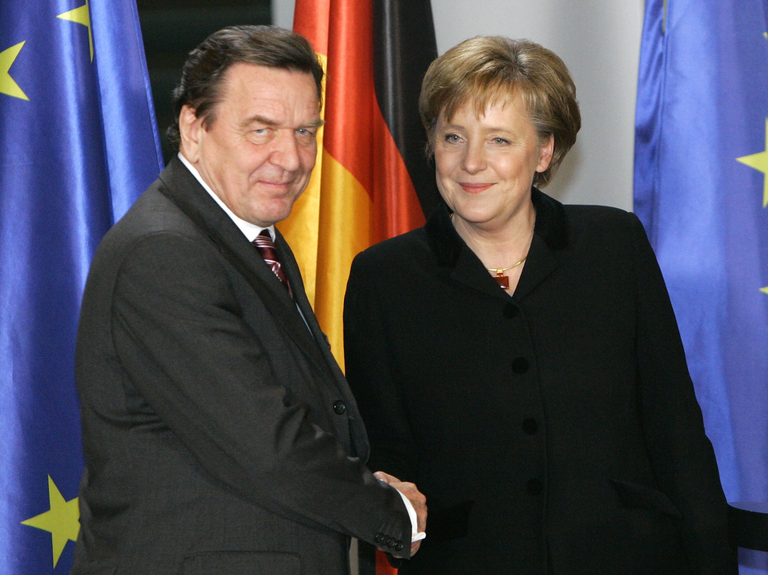 Outgoing chancellor Gerhard Schroeder shakes hands with newly appointed Angela Merkel in 2005