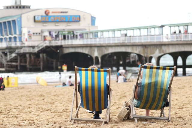 People relax on deckchairs (PA)