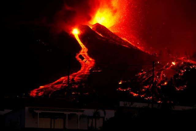 <p>Lava flows next to a house following the volcanic eruption on the Canary Island of La Palma on Sunday </p>