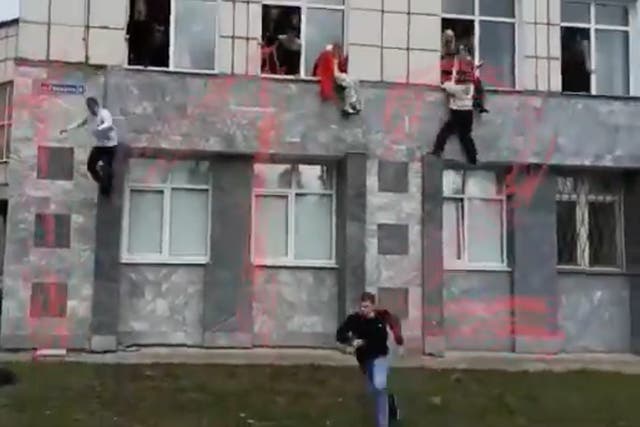 <p>Footage shows desperate students jumping from first-floor windows of the building</p>