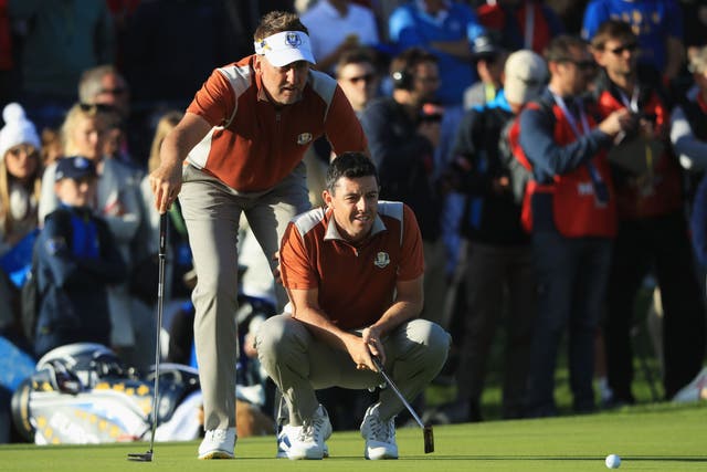 <p>Rory McIlroy and Ian Poulter line up a putt during the foursomes in 2018 </p>