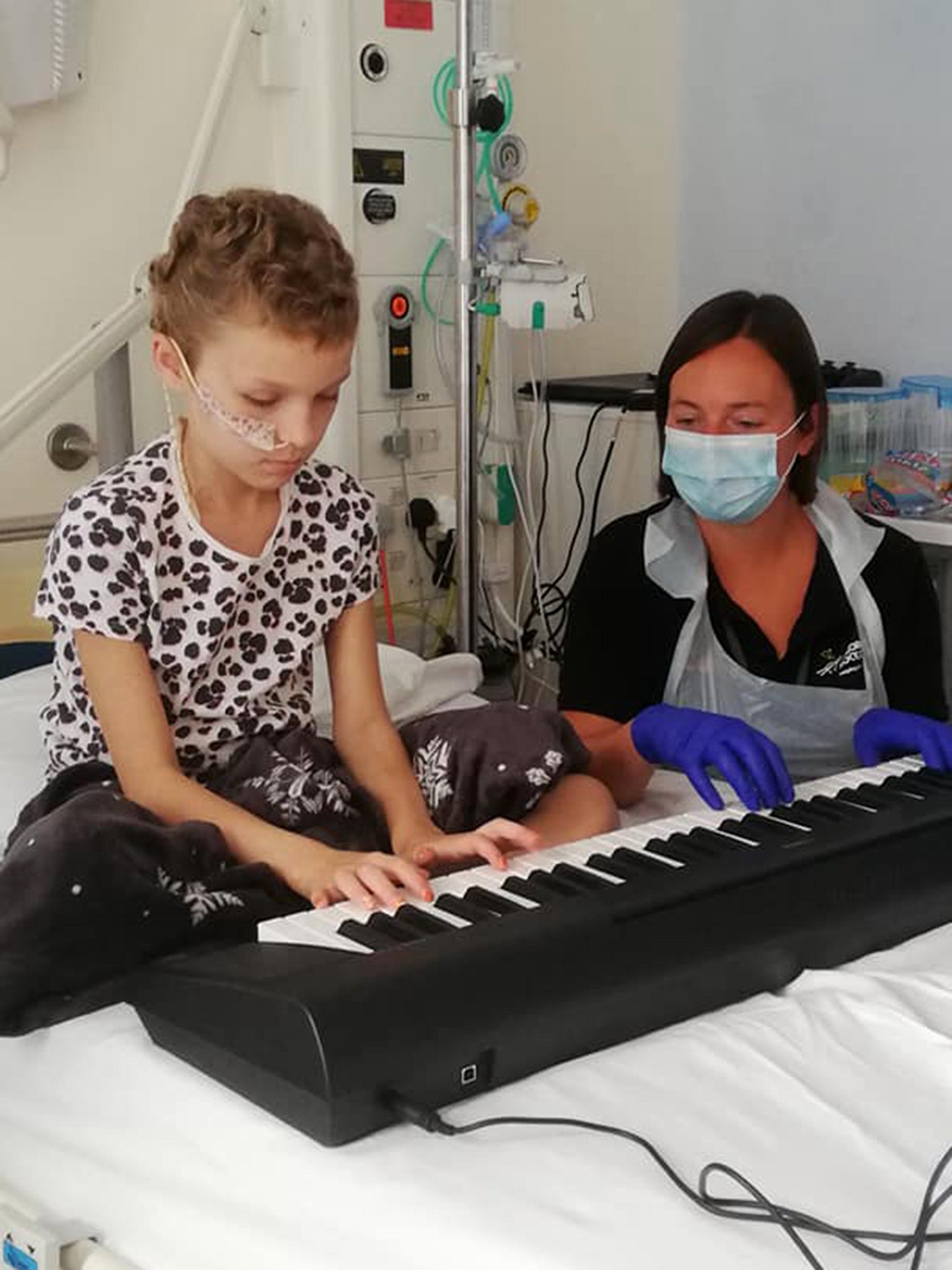 Sophie learns the piano with a hospital play assistant