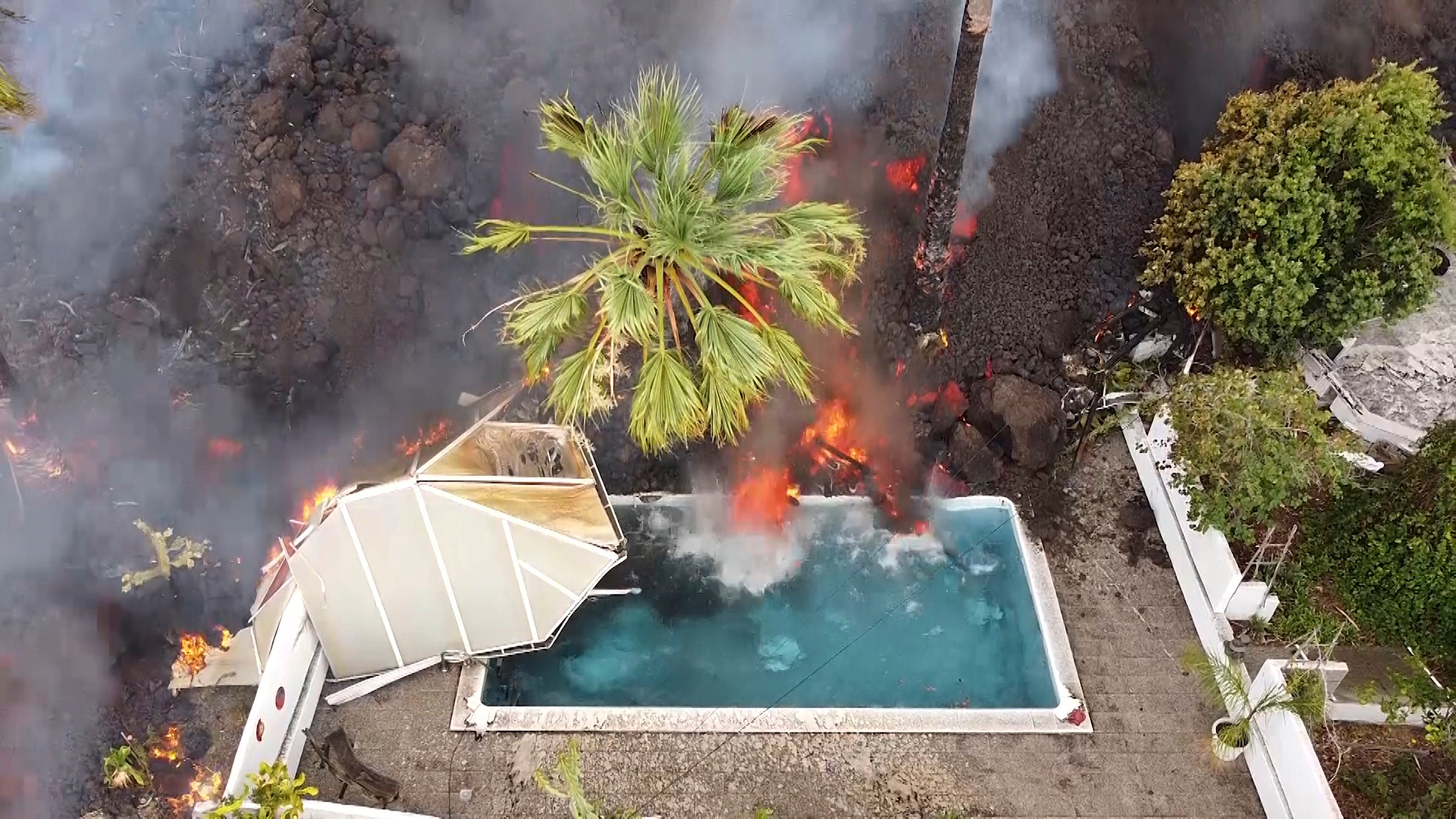 Hot lava reaches a swimming pool after an eruption of a volcano on the island of La Palma