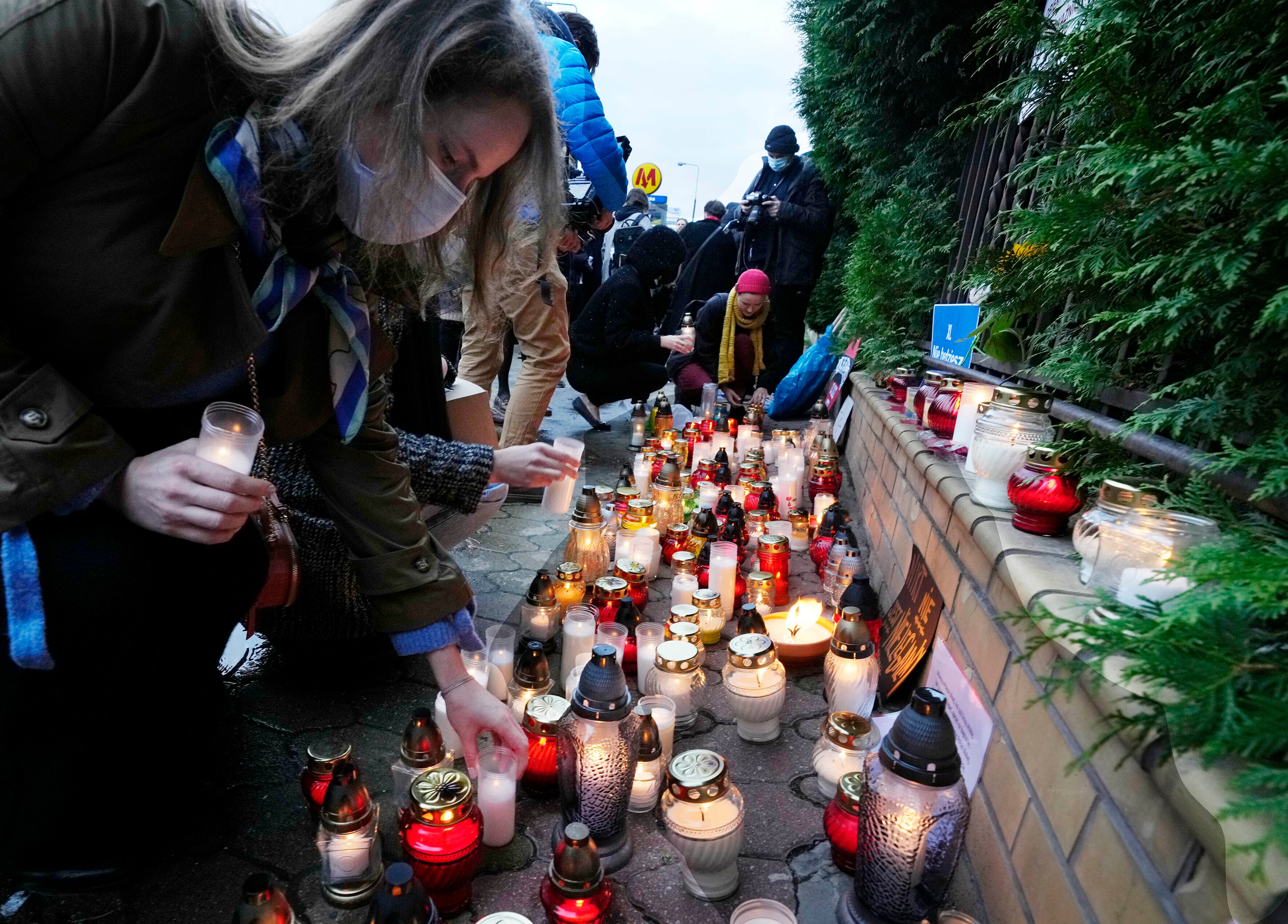 Warsaw residents place candles before the national Border Guards Headquarters in a sign of mourning for four migrants found dead over the weekend