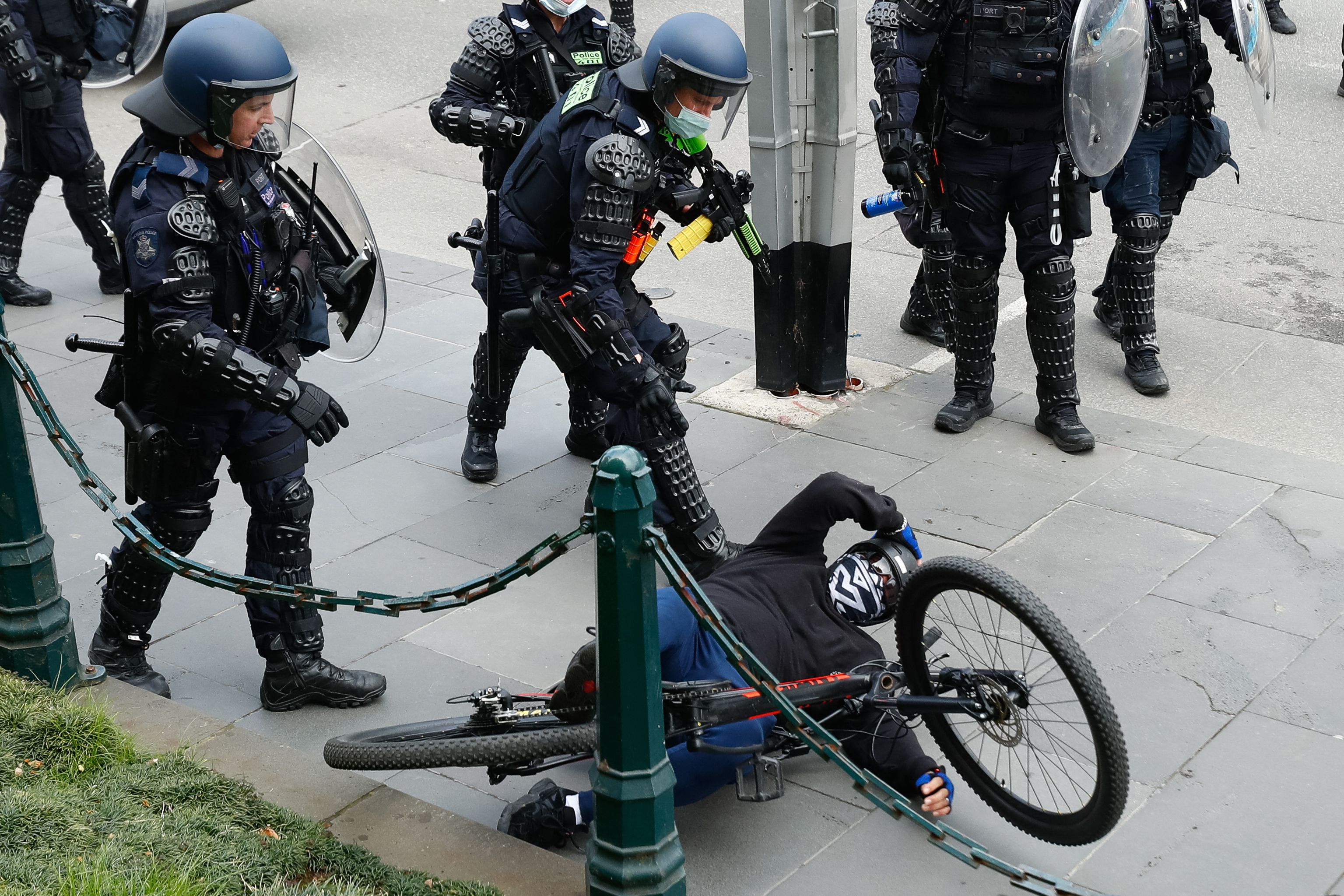 A demonstrator is handled by police officers attempting to disperse a protest against Covid-19 regulations in Melbourne on 21 September 2021