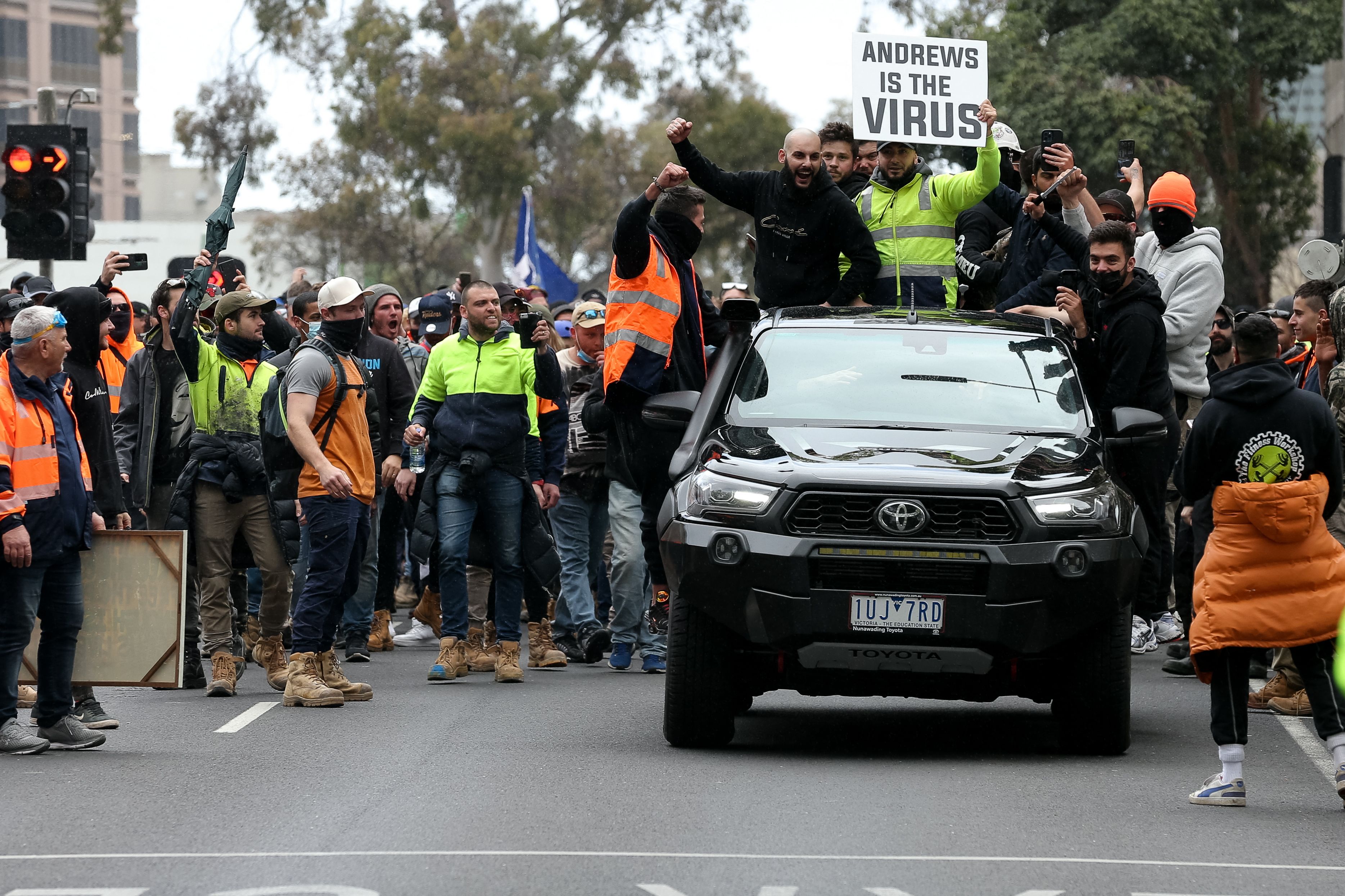 Construction workers and demonstrators attend a protest in Melbourne. The placard reads ‘Andrews is the virus,’ referring to Dan Andrews, the premier of Australia’s Victoria state