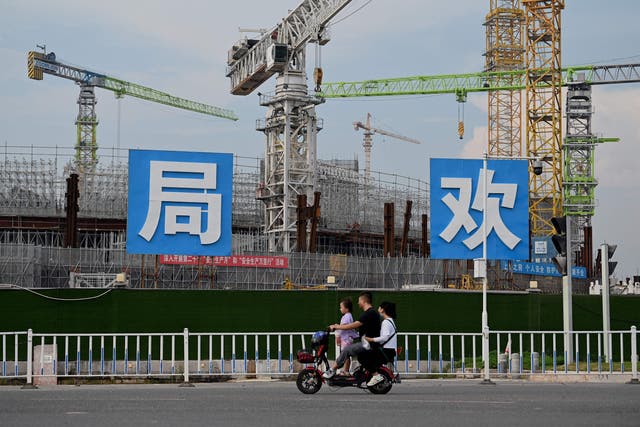 <p>People commute in front of the under-construction Guangzhou Evergrande football stadium in Guangzhou, China’s southern Guangdong province </p>