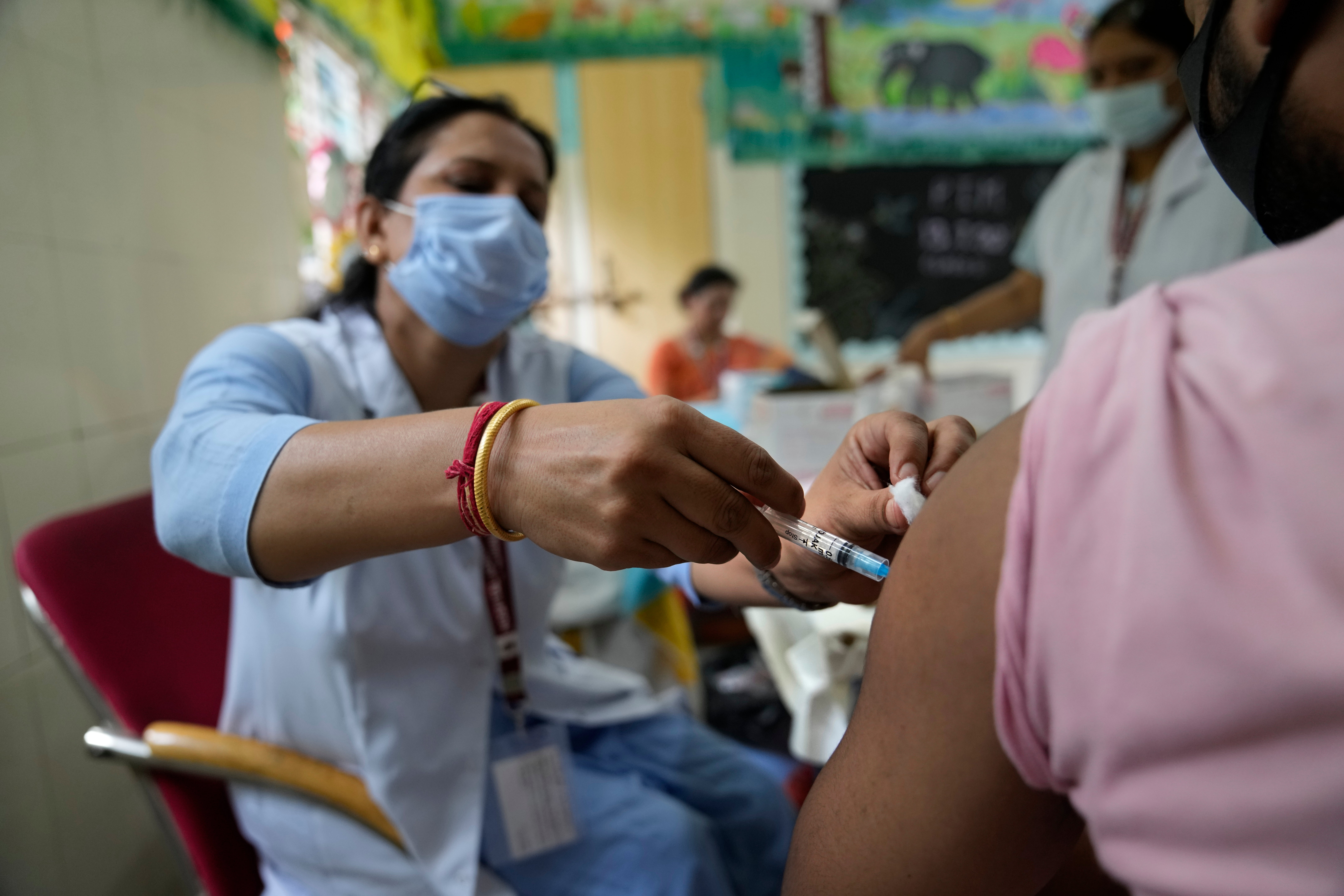 A health worker administers the vaccine for COVID-19 at a vaccination center set up at a government-run school in New Delhi, India, Tuesday, 21 September 2021