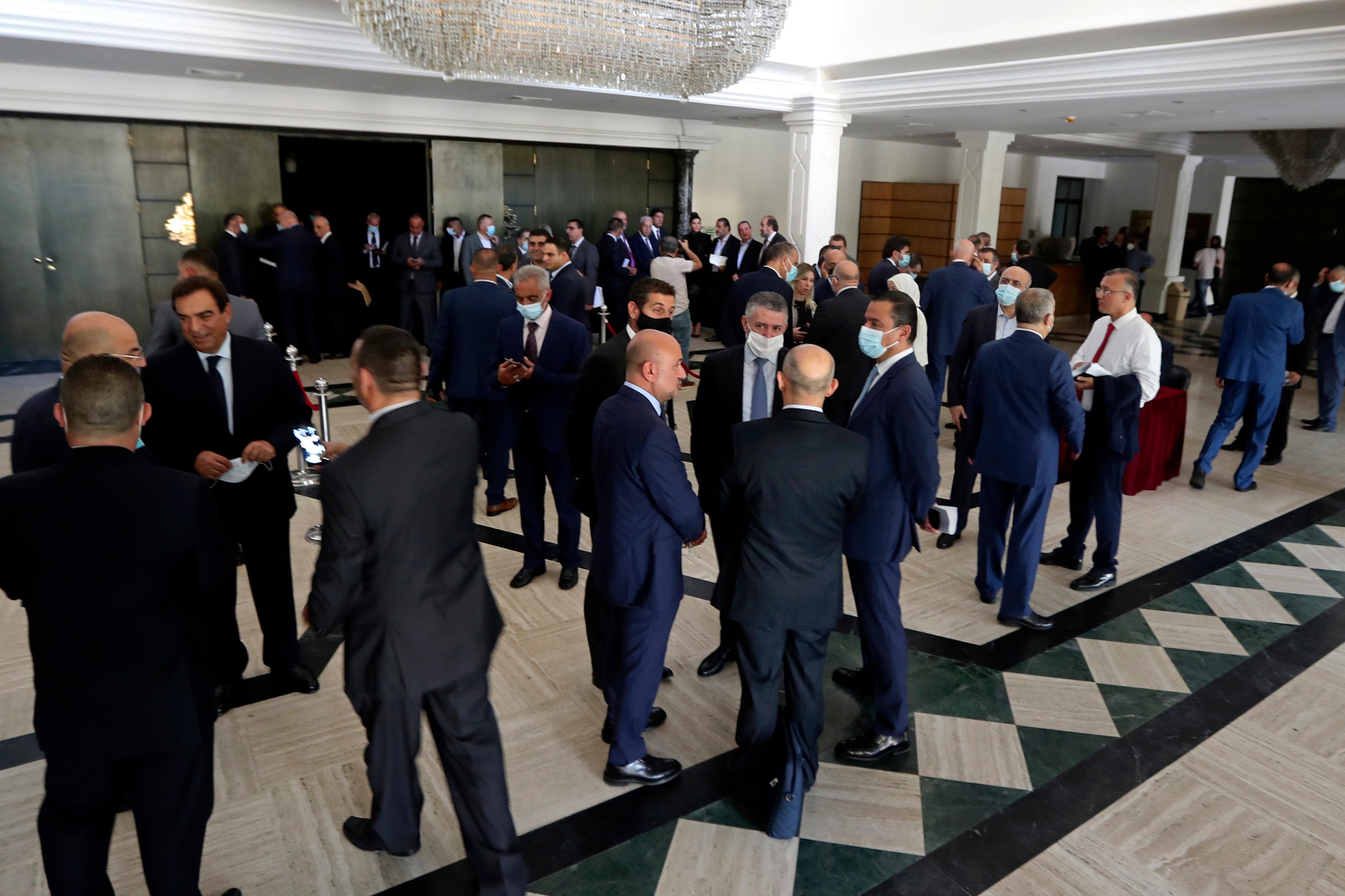 Lebanese lawmakers and ministers wait in the foyer of the Unesco Palace following a power outage in a meeting to confirm the new government