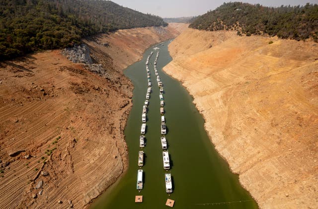 <p>Houseboats sit in a narrow section of water in a depleted Lake Oroville in California, which is currently at 23% of its capacity, suffering from extreme levels of drought</p>