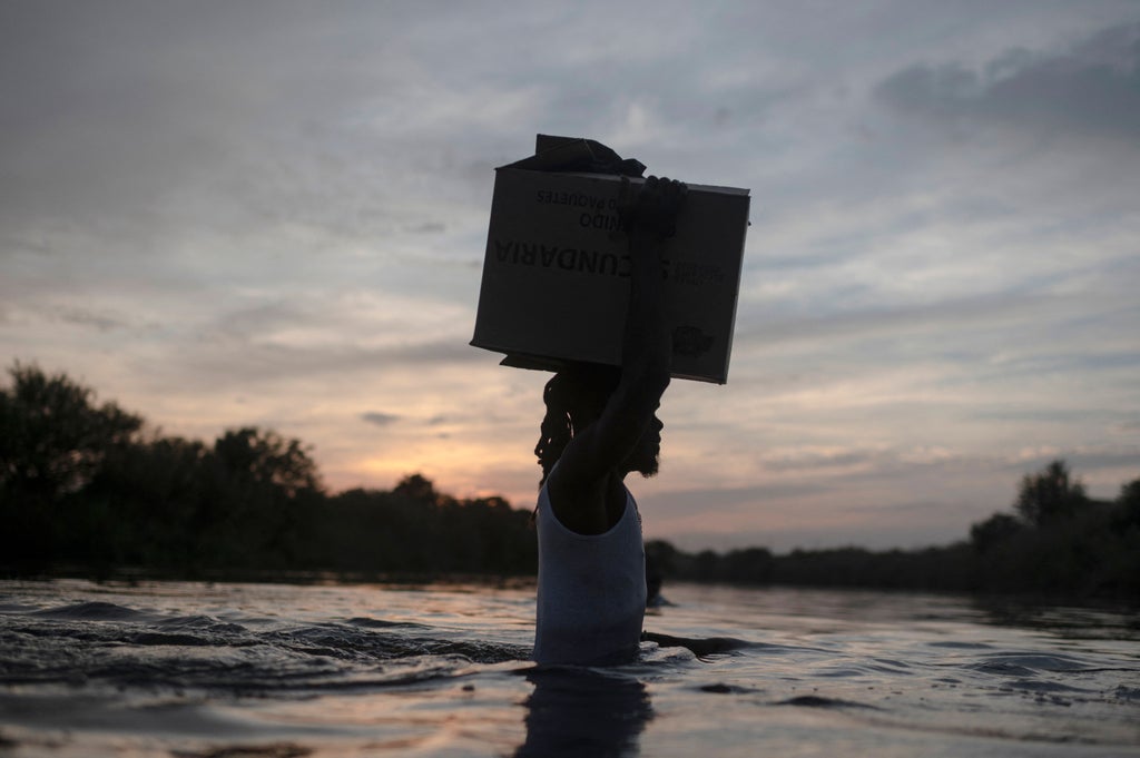 Harrowing photos at Texas border show desperate Haitian migrants crossing river with belongings
