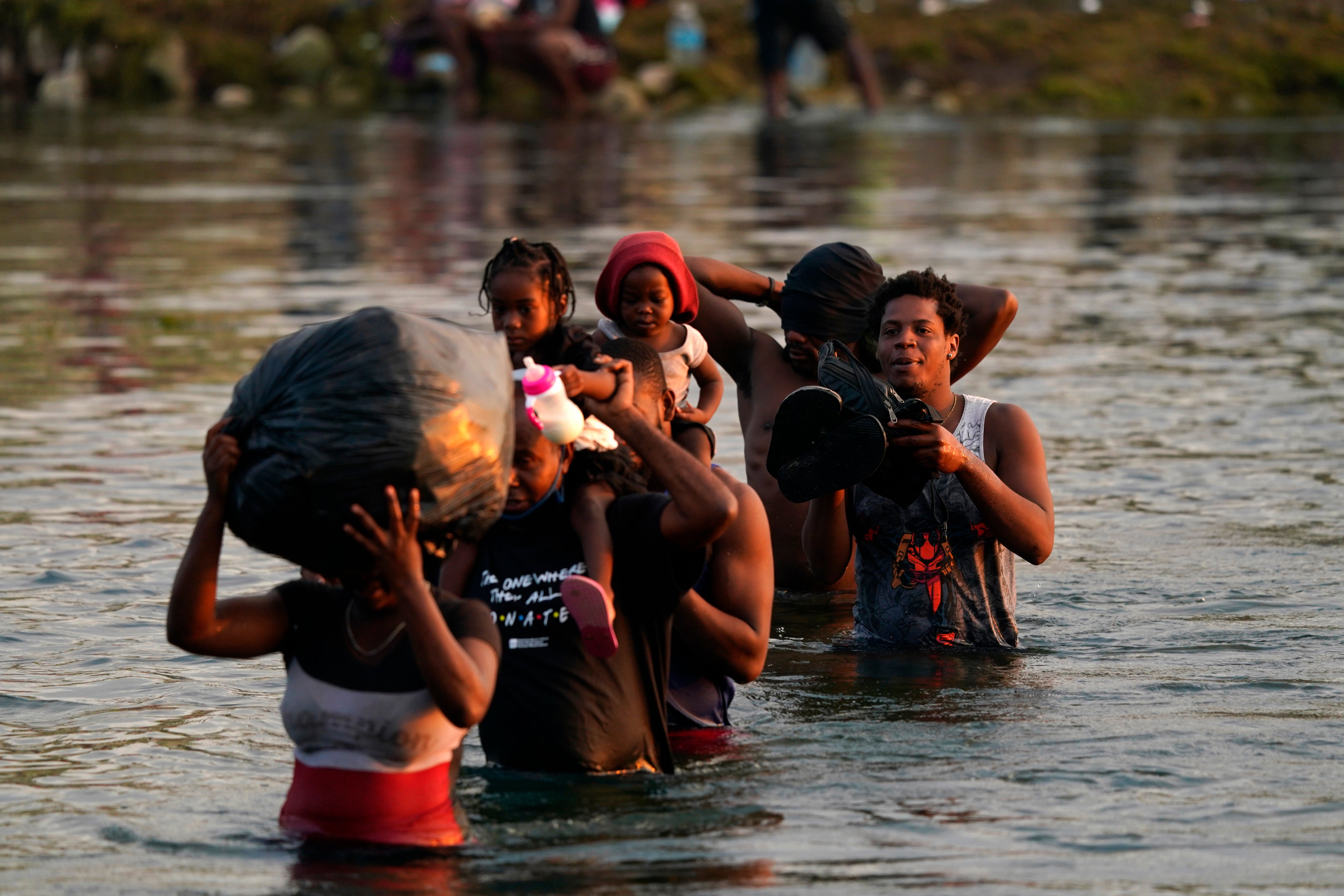 Migrants, many from Haiti, wade across the Rio Grande from Del Rio, Texas, to return to Ciudad Acuna, Mexico, Tuesday, 21 September 2021, to avoid deportation from the U.S