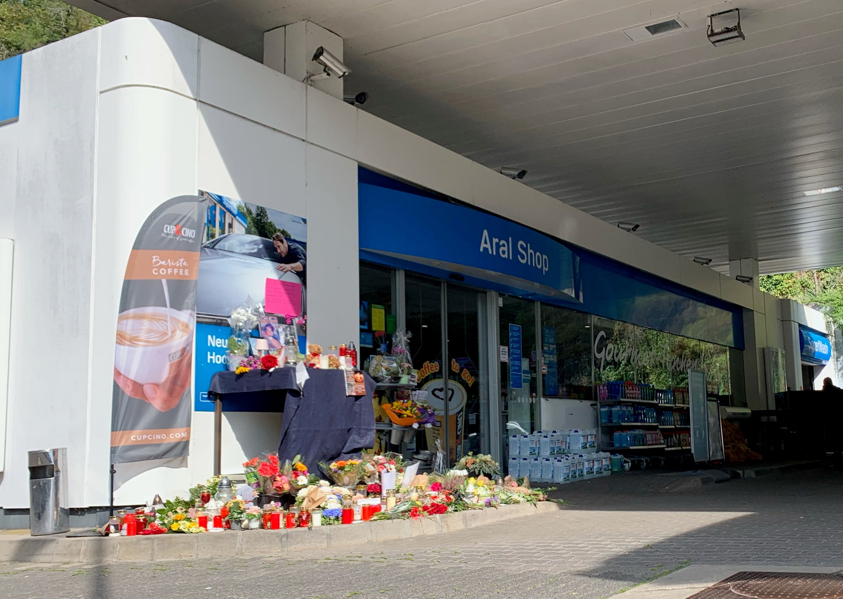 Flowers are placed in front of petrol station in Idar-Oberstein, Germany, where a man has been killed