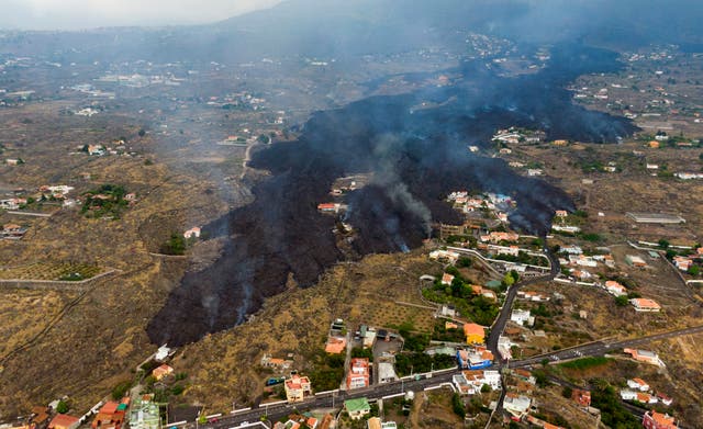<p>Lava from a volcanic eruption flows destroying houses on the island of La Palma in the Canaries</p>