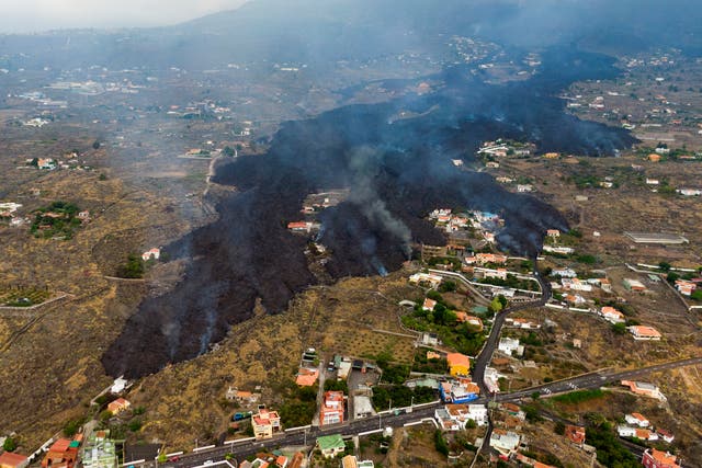 <p>Lava from a volcanic eruption flows destroying houses on the island of La Palma in the Canaries</p>