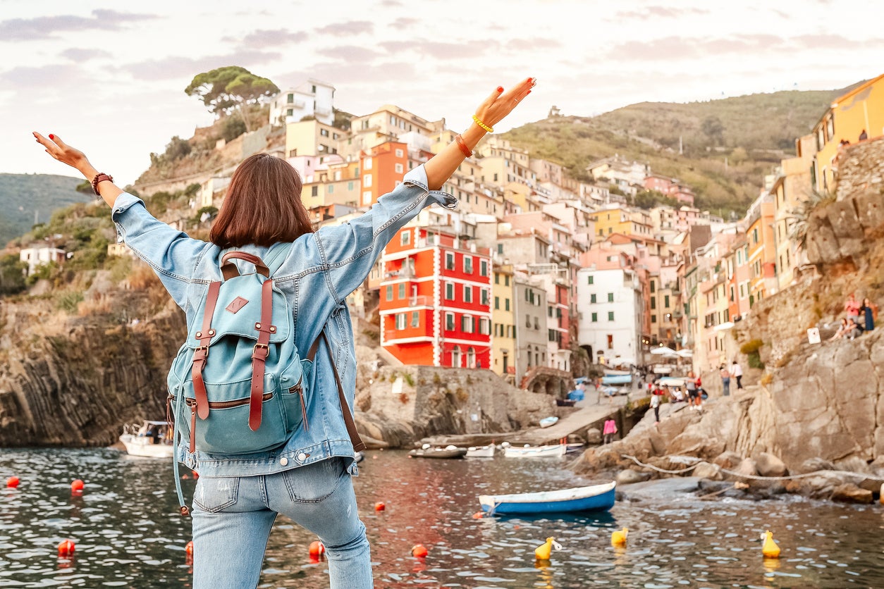 A traveler enjoys the view on the famous landmark town Riomaggiore in Italy’s Cinque Terre