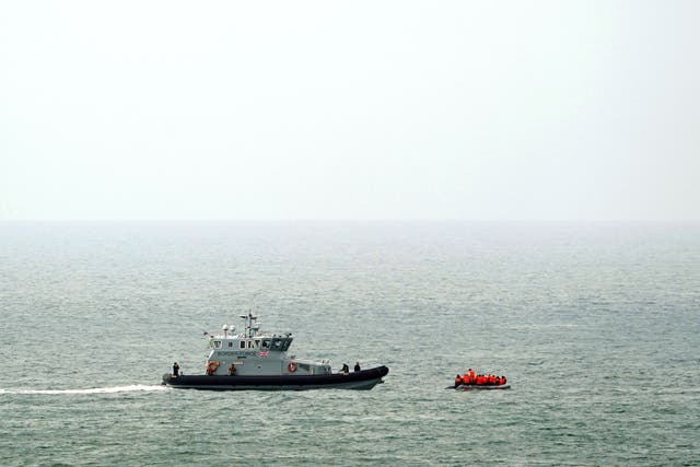 <p>A Border Force vessel intercepts a group of people thought to be migrants in a small boat off the coast of Dover in Kent</p>